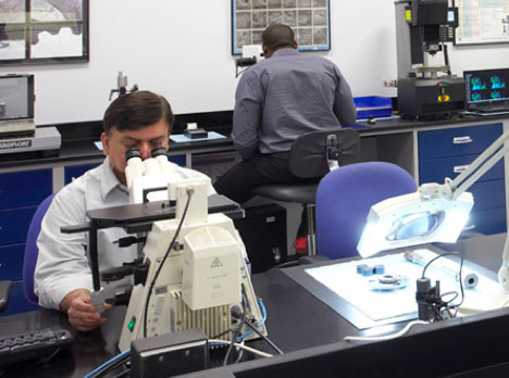Honda Performance Development lab technician at a microscope